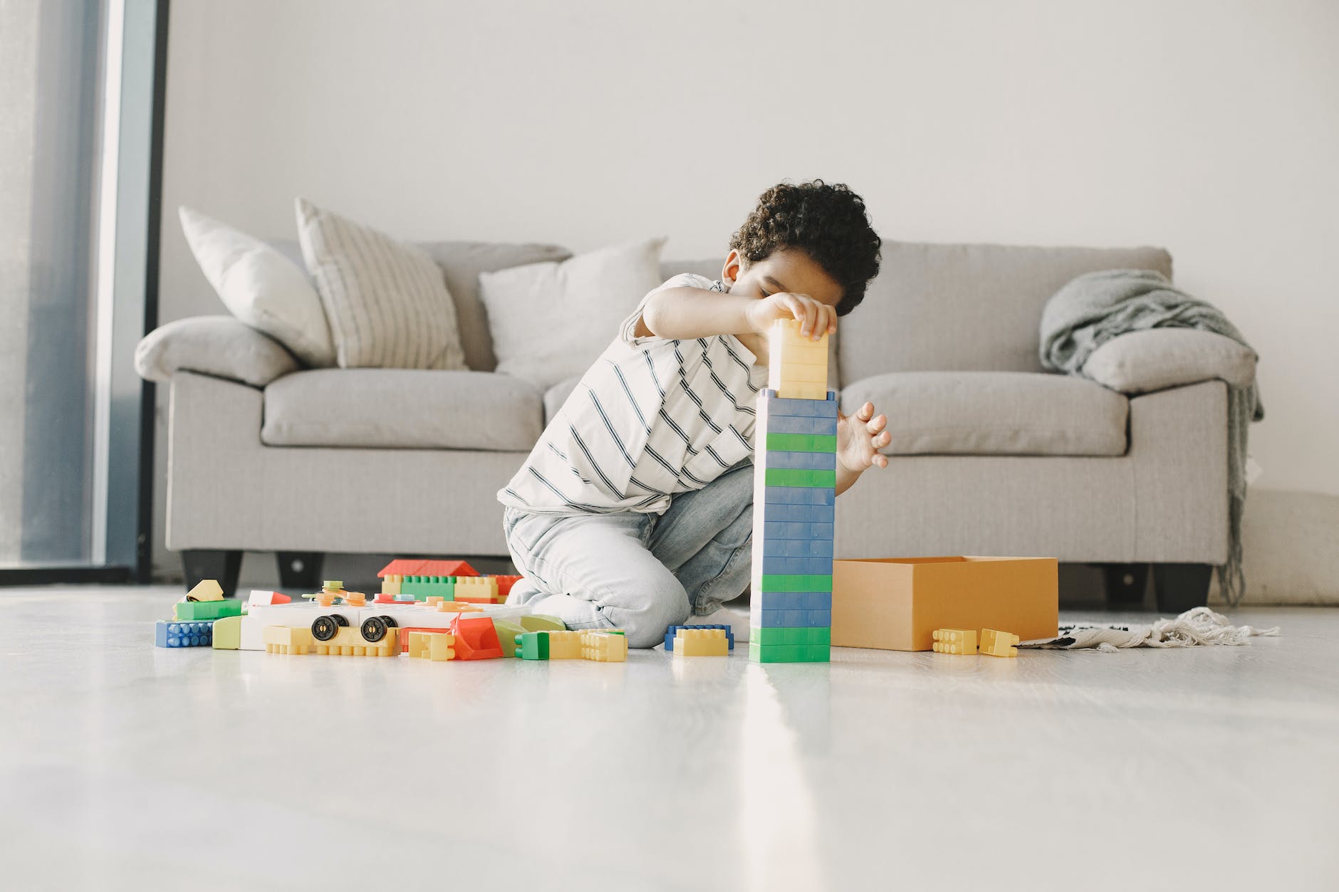 little boy building with blocks in a living room